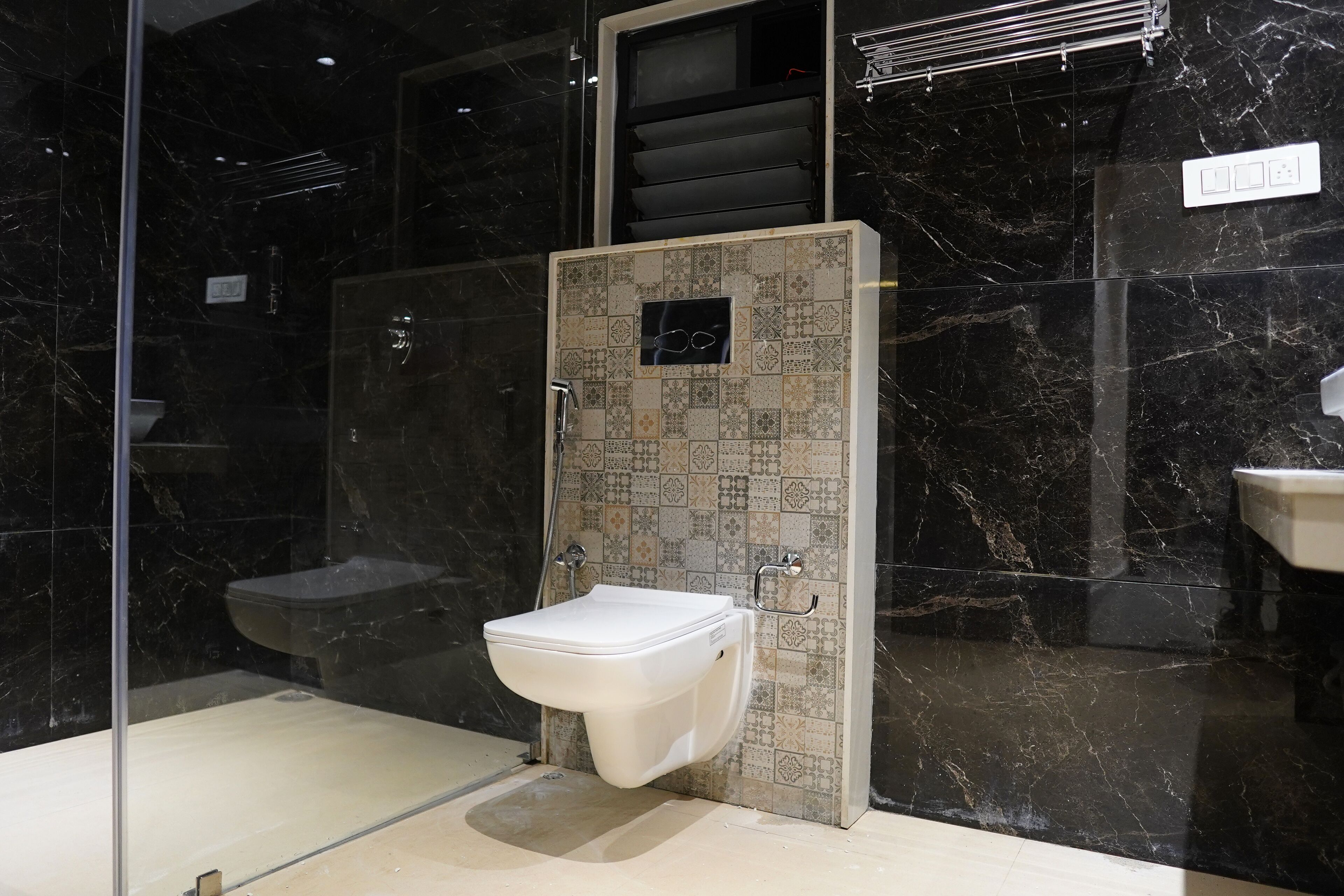 A modern bathroom with a glass-enclosed shower, a white toilet, and a sink.