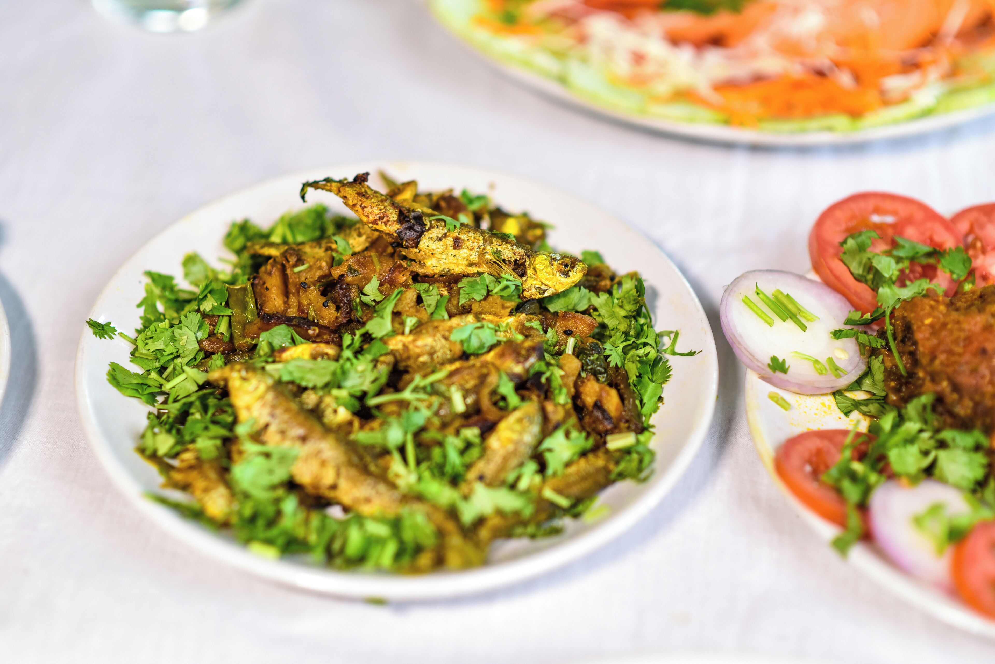 Un plato de pescado frito decorado con hierbas frescas.