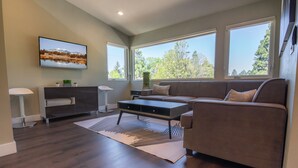 Una sala de estar moderna con sofá, mesa de centro y televisor.