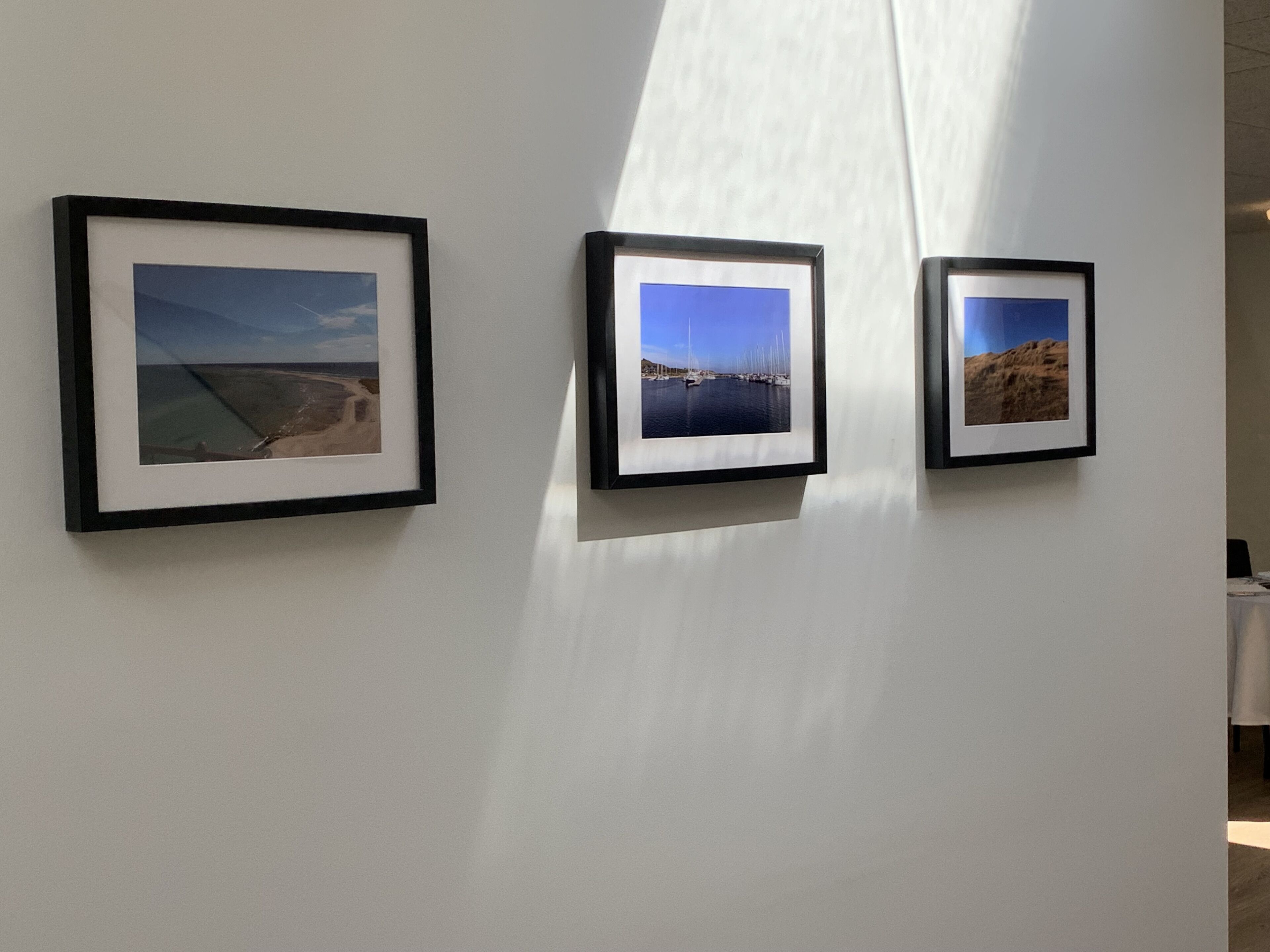 Three framed photographs on a wall.