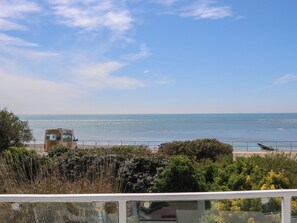 Une vue sur la côte, avec un ciel dégagé, une plage et un bâtiment portant une enseigne.