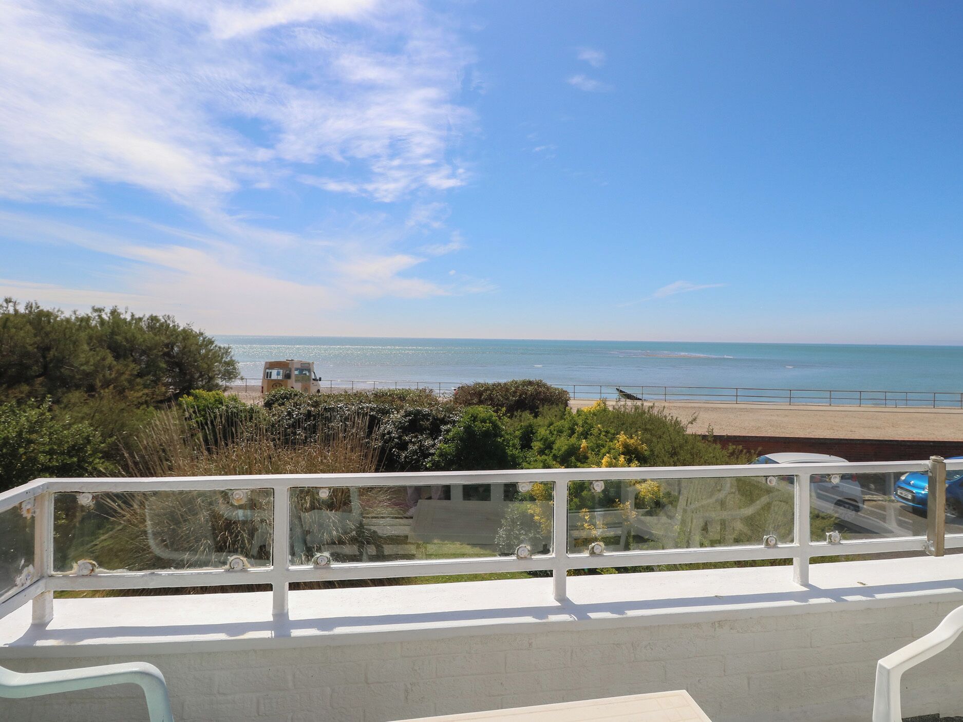 A balcony with a clear view of the beach and ocean.