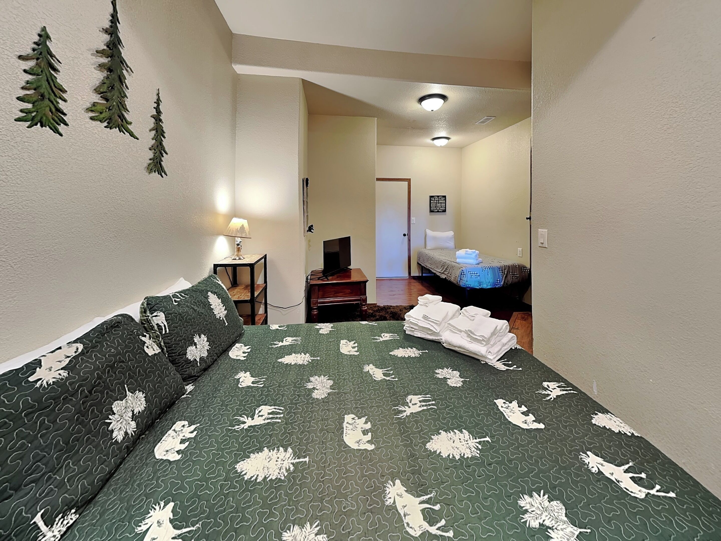 A room with a bed, a desk, a chair, and a lamp.