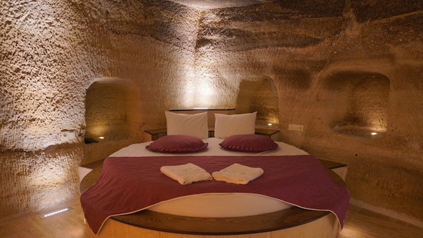 A circular bed with a wooden frame, two pillows, and a blanket. - Göreme Cave Lodge (Nevsehir)