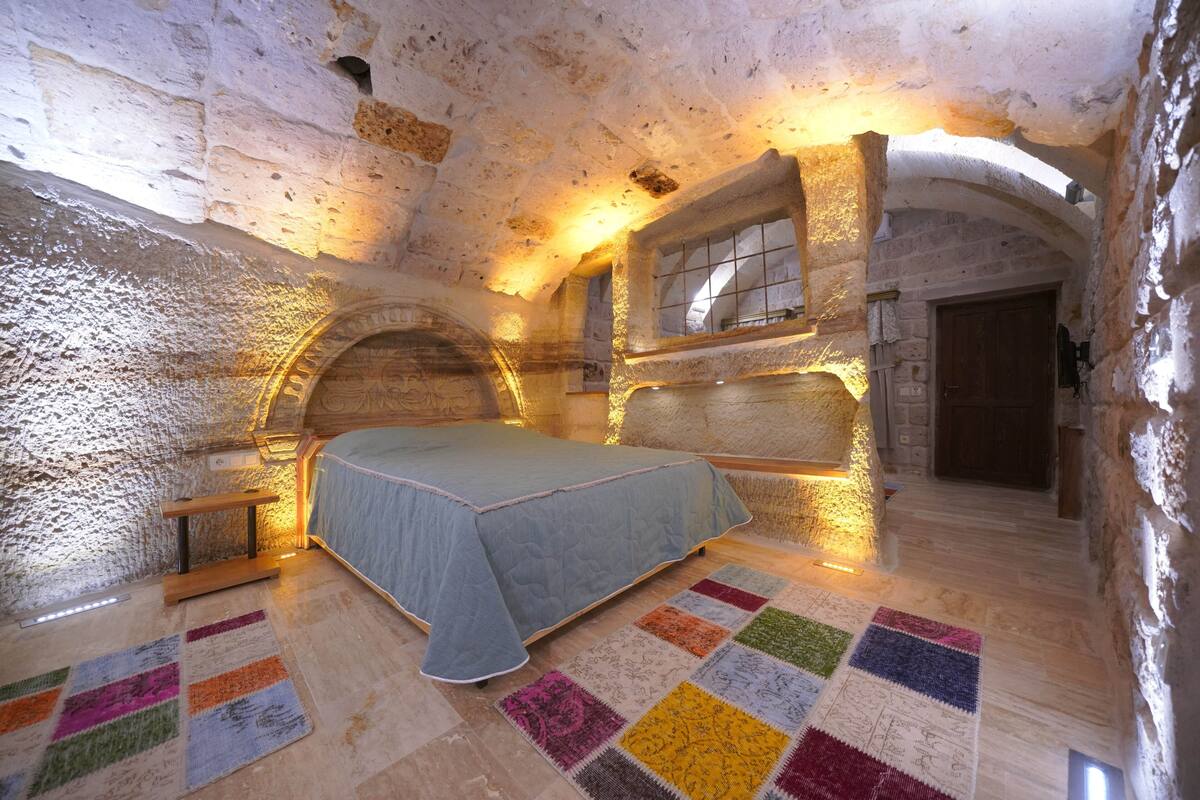 A bedroom with a bed, a window, and a door.