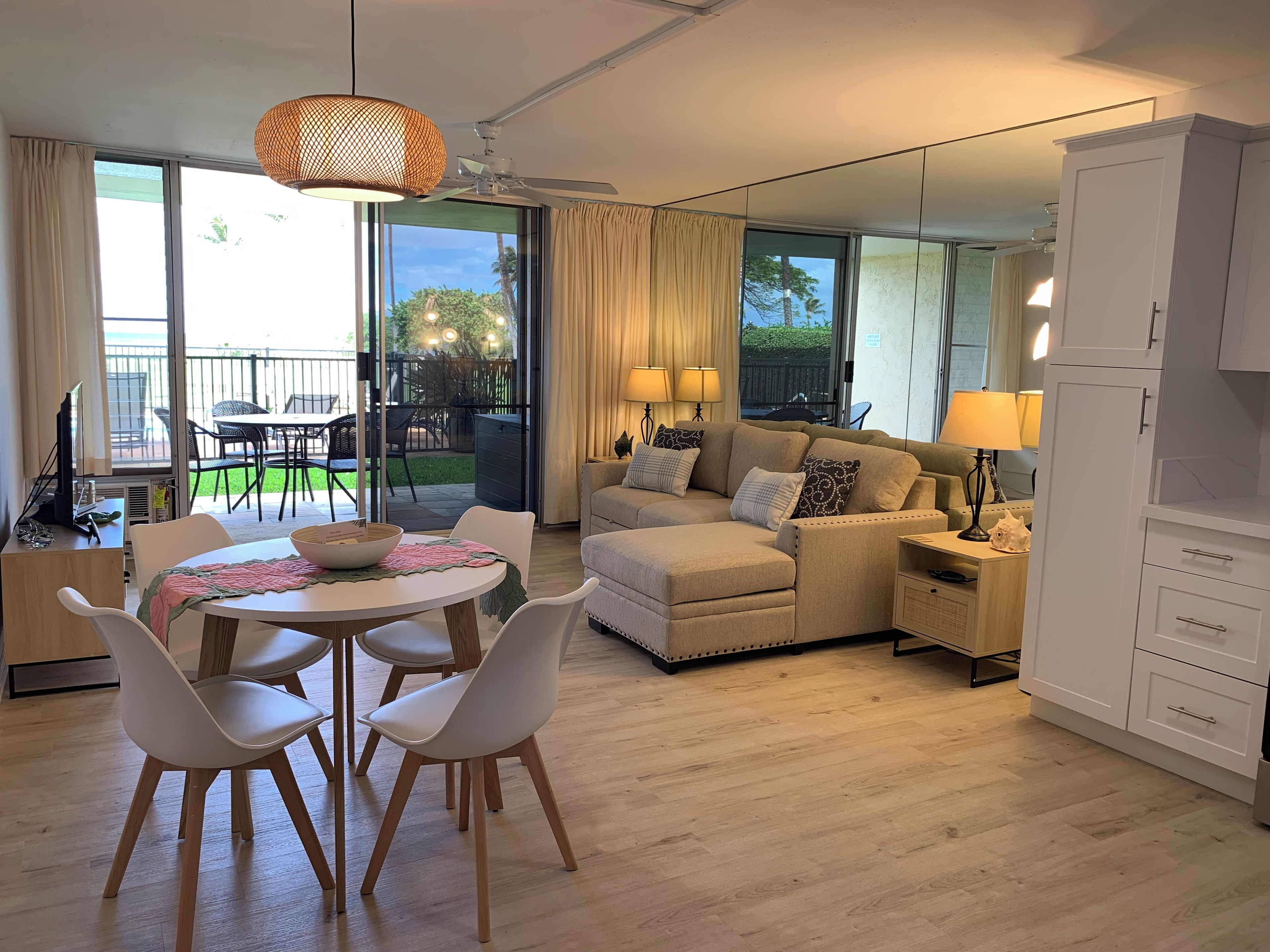 A modern living room with a sofa, chairs, a dining table, and a kitchen area.