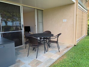Une terrasse avec une table et des chaises, un téléviseur et un panneau d’avertissement fixé au mur.