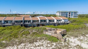 A beachfront hotel with multiple-story buildings featuring balconies and outdoor seating areas. - Stunning Ocean Front Condo (Oceans 6) (Pine Knoll Shores)