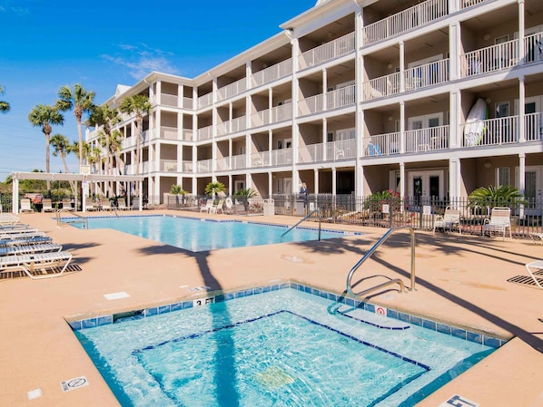 A hotel with a large pool area, multiple balconies, and palm trees. - Short Walk to the Sand! Ground Level Perdido Key Condo (Perdido Key)