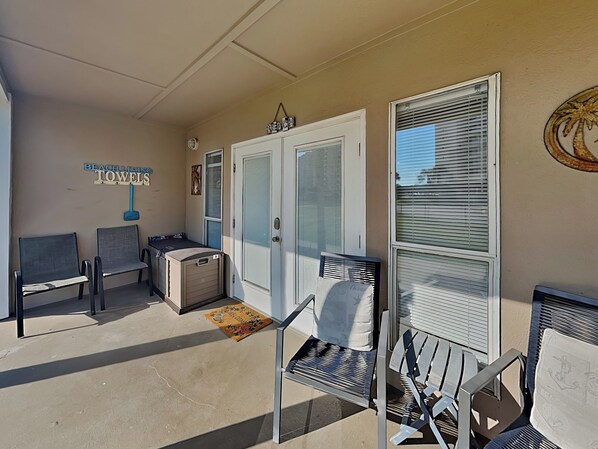 A beach-themed outdoor seating area with metal chairs and a bench, a door with a towel rack, and a sign that reads "BEACH LIMIT TOWELS". - Short Walk to the Sand! Ground Level Perdido Key Condo (Perdido Key)