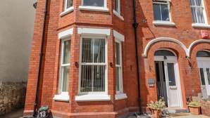 A red brick building with white-framed windows and a door.