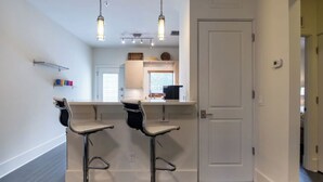 A modern kitchen with two bar stools, pendant lighting, and a white door. - Walk The Downtown Village of Winter Park!!! (Winter Park)