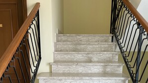 A staircase with marble steps and black metal railings.