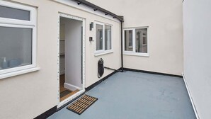 A narrow alleyway with a door leading to a room, a window, and a small window on the adjacent building. - Host & Stay | Ings Lane (Saltburn-by-the-Sea)