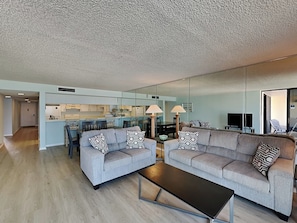 Relax in this stylish living room with a sofa, coffee table, and dining area.