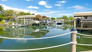 Un port de plaisance avec des bateaux amarrés, une zone abritée et une barrière faite de cordes.