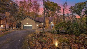 A two-story building with a garage, surrounded by trees and a driveway. - Poconos Retreat w/ Pool and Lake Access (Lake Ariel)