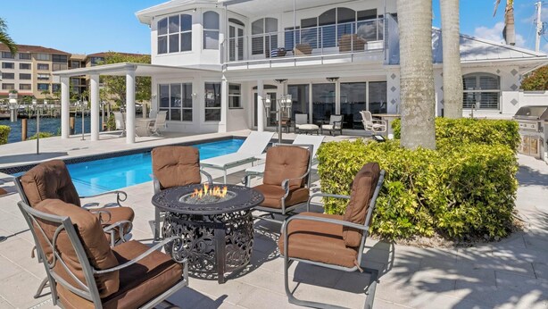 A modern house with a pool, outdoor seating, and a fire pit. - Dolce Vita Villa by Distinctive Beach Rentals (Cape Coral)