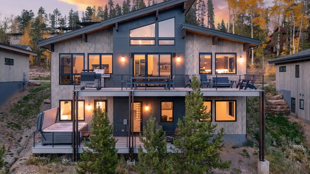 A modern two-story house with large windows, a balcony, and a deck. - Rendezvous Game Trail | Luxe Mountain Home | Brand New Build | Amazing Views (Fraser)