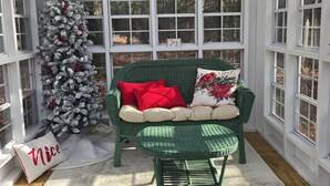 Une pièce chaleureuse avec un canapé vert, un sapin de Noël et un banc.
