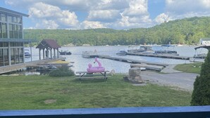 A lakeside view with a dock, boats, and a grassy area. - Charming 2-bedroom cottage by the water (Utterson)