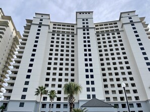 A high-rise building with multiple floors, featuring a grid of windows and balconies.
