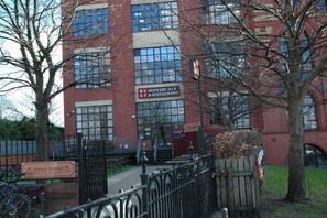 A red brick building with large windows and a sign for a brewery-bar and restaurant.