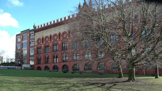 A large red brick building with arched windows and a symmetrical facade.