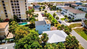 Un quartier résidentiel situé sur la côte, doté d’une piscine, de bâtiments à plusieurs étages et offrant une vue sur la plage.
