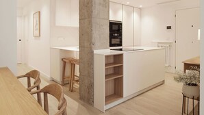 A modern kitchen with white cabinetry, a central island, and a built-in oven.