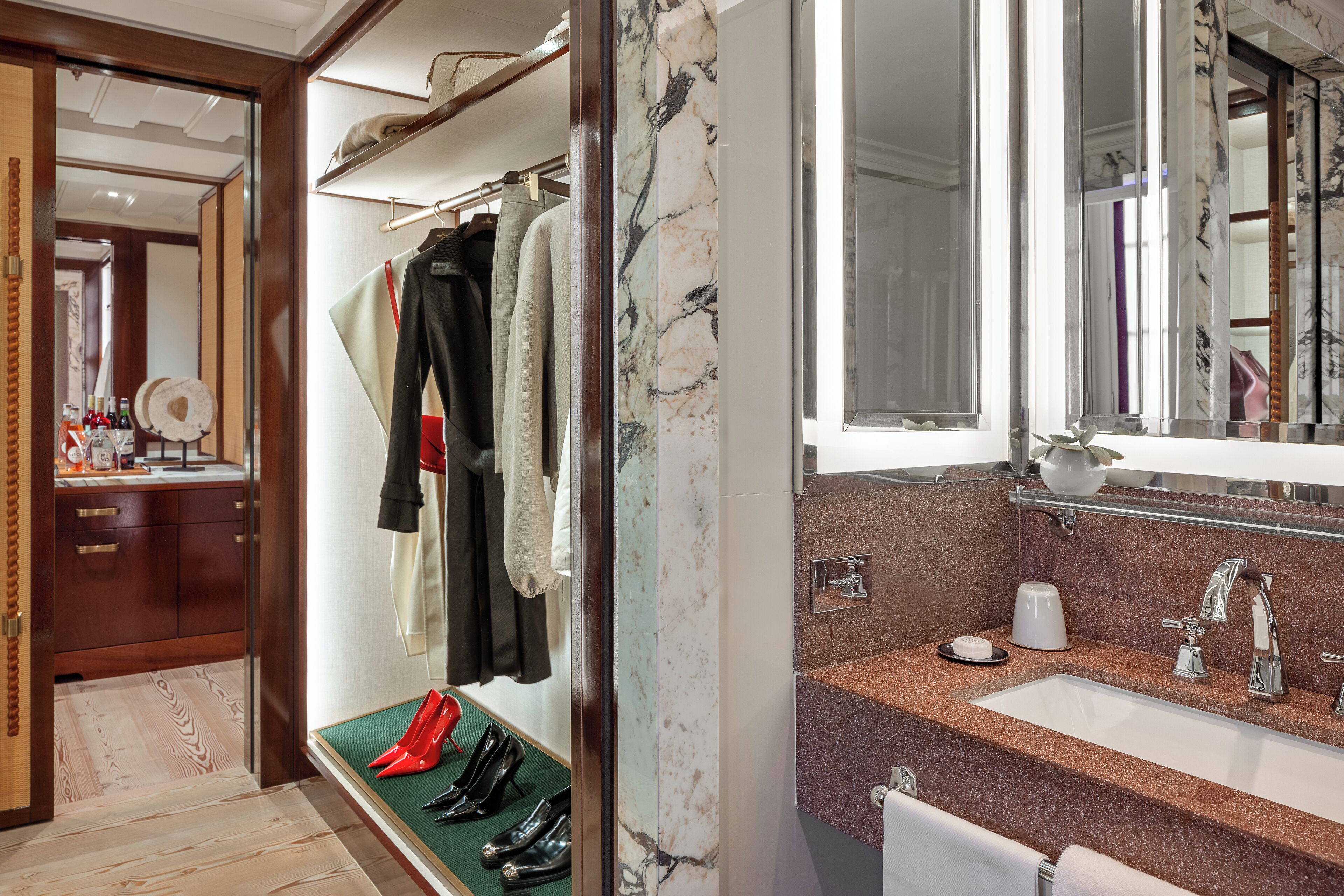Ein modernes Badezimmer mit Marmor-Waschtisch, einem großen Spiegel und einem integriertem Waschbecken.