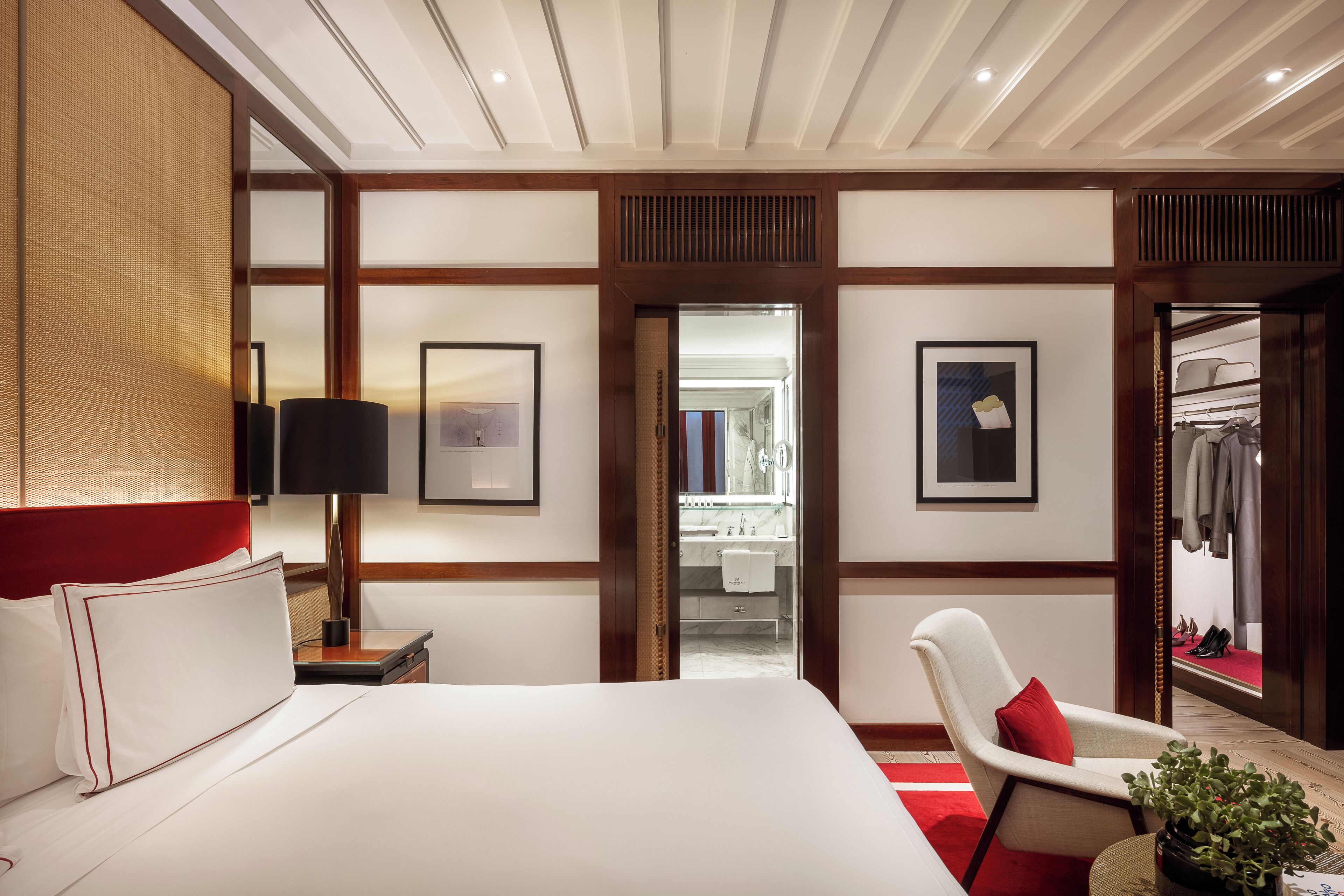 Una camera d'albergo con un letto grande, una sedia, una scrivania, uno specchio e un armadio.