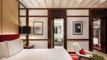 Una camera d'albergo con un letto grande, una sedia, una scrivania, uno specchio e un armadio.