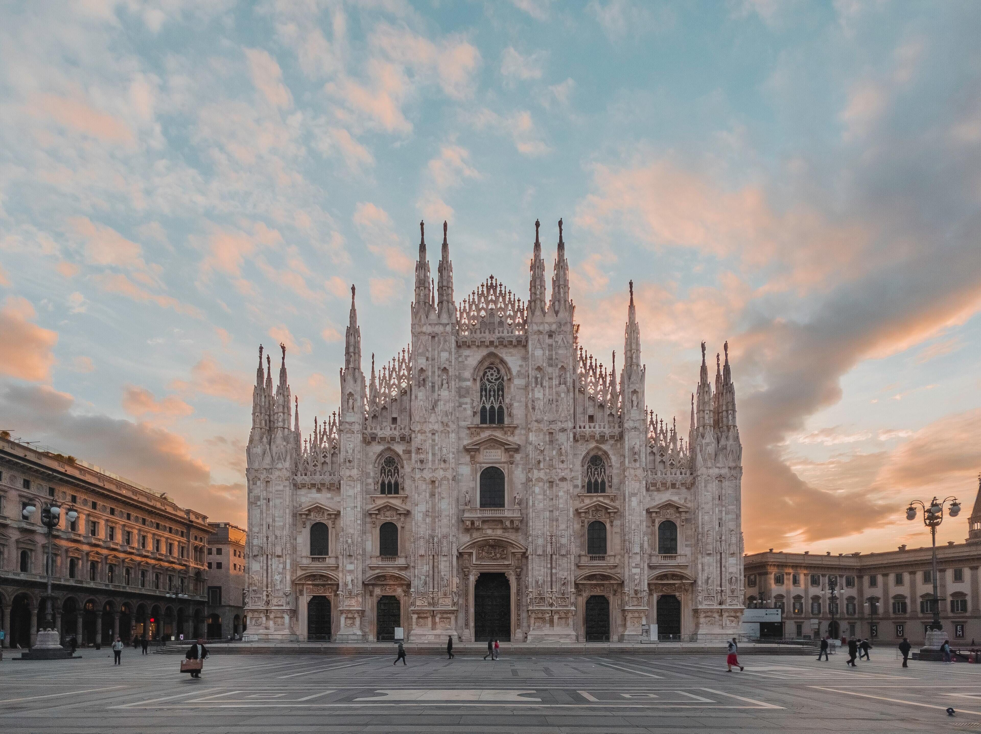 Una imponente catedral con arquitectura gótica intrincada, amplias puertas centrales y múltiples agujas.