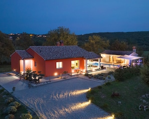 A two-story house with a swimming pool and outdoor seating area.