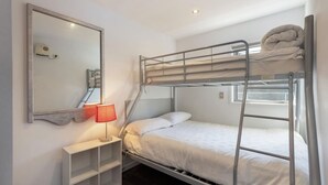 A bunk bed room with a mirror, a lamp, and a shelf. - Welcome to Ballarat Bungalow. A Chic Central Stay with Easy Access to Queenstown’s Best! (Queenstown)