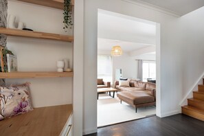 Un salon moderne avec un canapé, une table basse et un escalier.