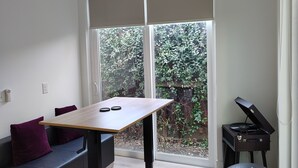 A modern room with a wooden table, a black exercise ball, a sofa with purple cushions, and a record player. - Lovely near Forsyth Park (Savannah)