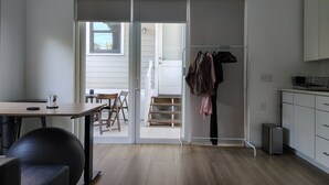 A modern kitchen with white cabinets, a refrigerator, and a dining area with a table and chairs. - Lovely near Forsyth Park (Savannah)