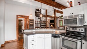 A modern kitchen with white cabinets, stainless steel appliances, and a wooden ceiling. - Luxurious condominium in Perfect Location on Bridge Street, Near Gondolda 1!! (Vail)