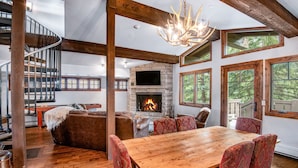 A spacious living area with a fireplace, wooden dining table, and comfortable seating. - Luxurious condominium in Perfect Location on Bridge Street, Near Gondolda 1!! (Vail)