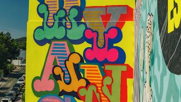 Un letrero colorido con estilo graffiti y un gran símbolo 'R' en la parte superior.