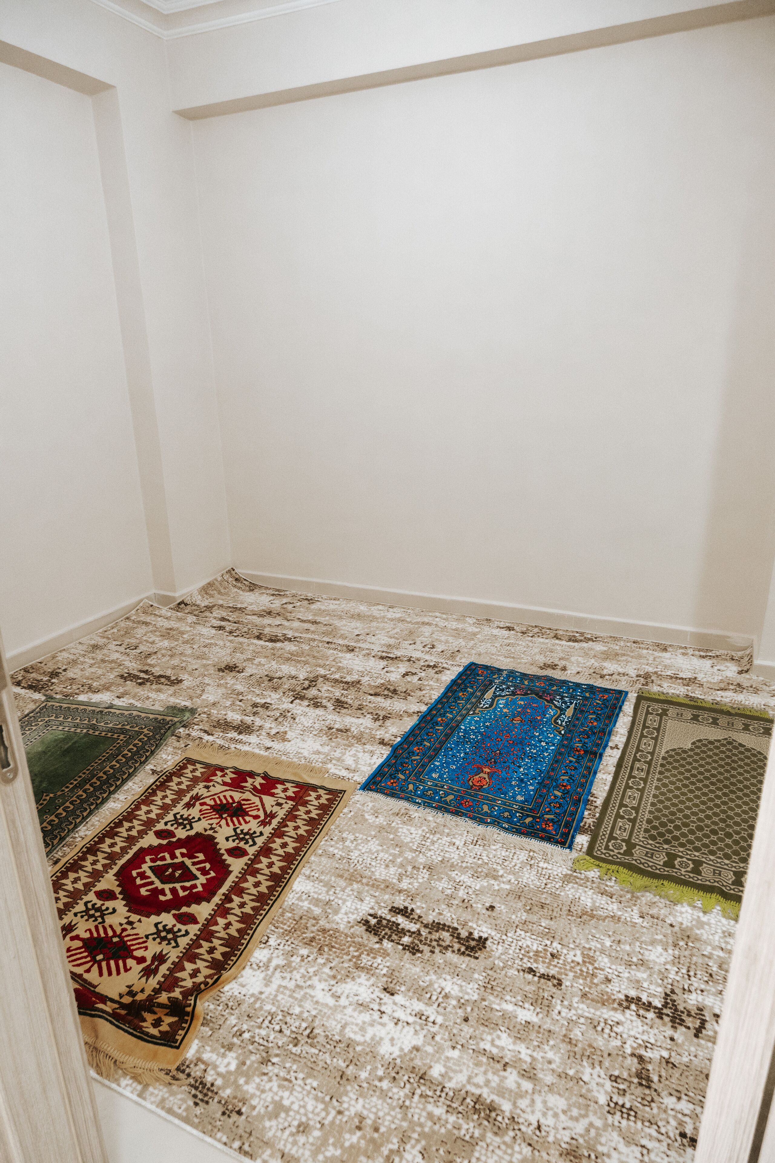 A room with a carpeted floor and a door.