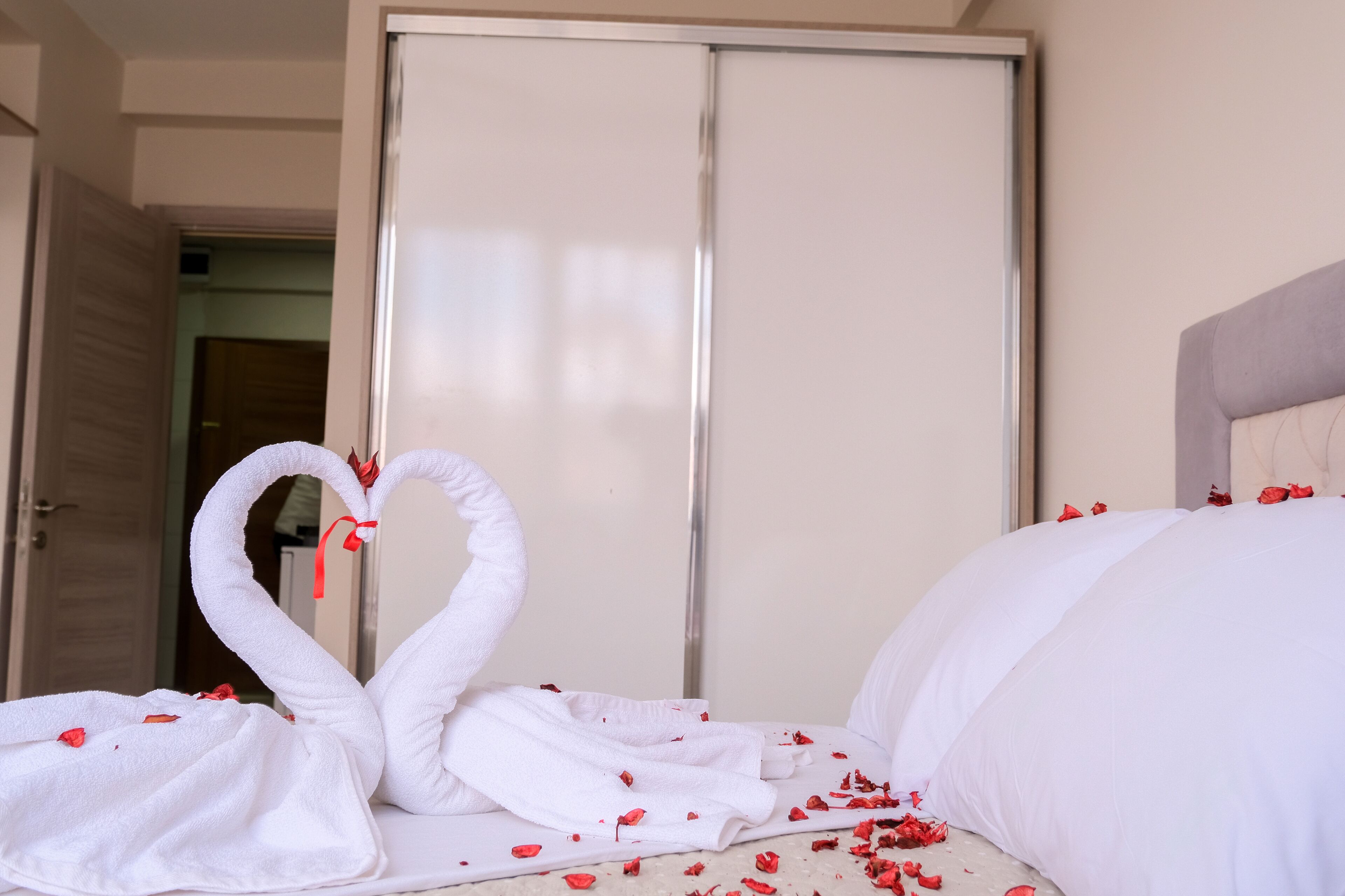 A hotel room with a bed, a wardrobe, and a door.