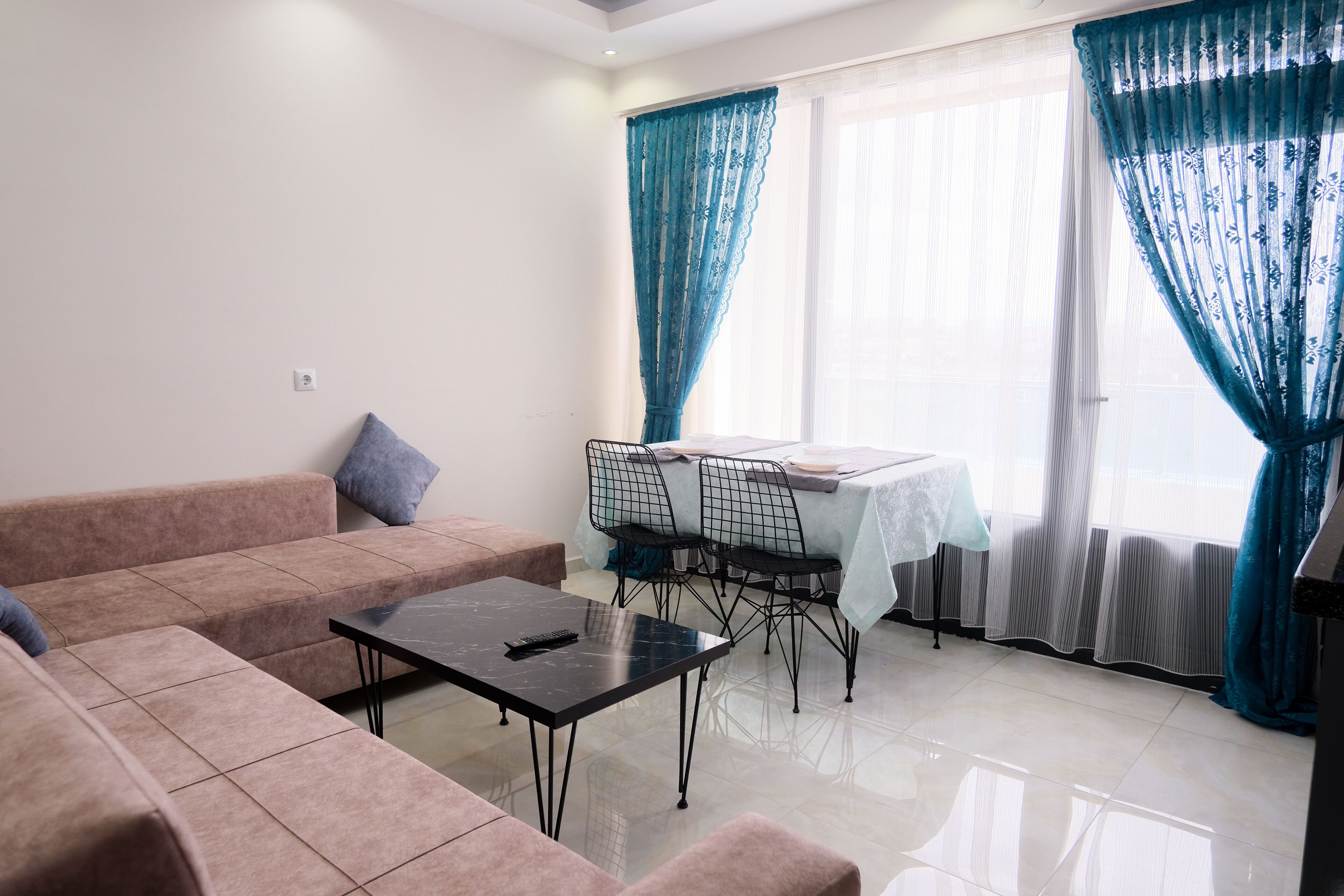 Una sala de estar con un sofá, una mesa de centro y una mesa de comedor con sillas.