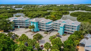 A large, multi-story hotel with a central courtyard and multiple balconies. - The Skimmer Condo: Downtown on the Bay - Nature Views - Bird watching (Cedar Key)