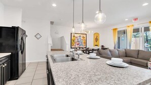 A modern kitchen with granite countertops, stainless steel appliances, and pendant lighting. - Private Views & Theme Rooms, Perfect for Families! (Davenport)