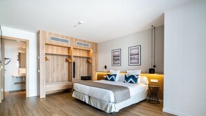A modern bedroom with a large bed, wooden wardrobe, and a small table with a lamp. - THB Bamboo Alcudia Hotel - Adults Only (Alcúdia)