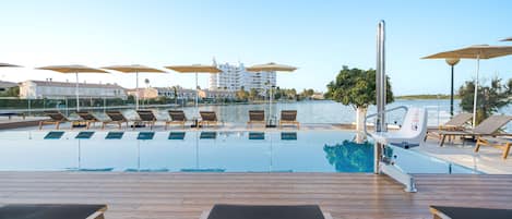 Outdoor pool, open 10:00 AM to 7:00 PM, pool umbrellas, pool loungers