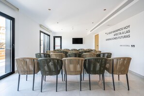 A conference room with multiple chairs arranged in rows, a large window, and a quote on the wall. - THB Bamboo Alcudia Hotel - Adults Only (Alcúdia)